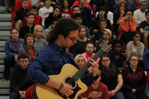 Connor plays a song on his guitar in honor of the veterans