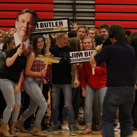 Students show their love for Jim Butler by making signs of his head and name. 