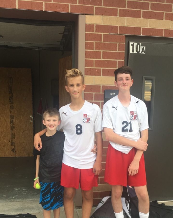 Aidan Holtz (middle) poses with little brother and teammate, Jackson Crangle (right) after a successful game.