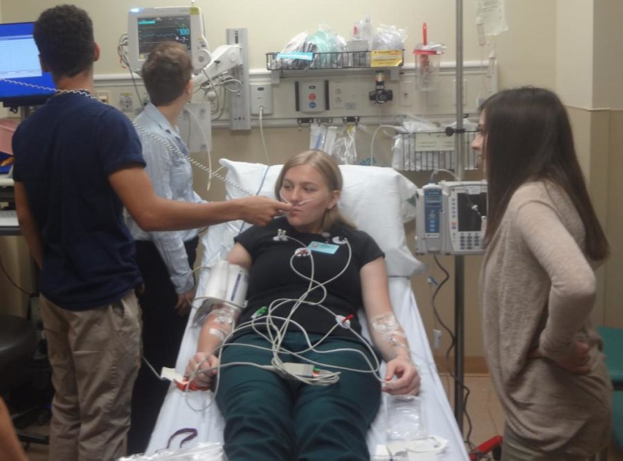 The HealthCare academy students set up equipment to monitor Savannah Rackovan’s vital signs.
