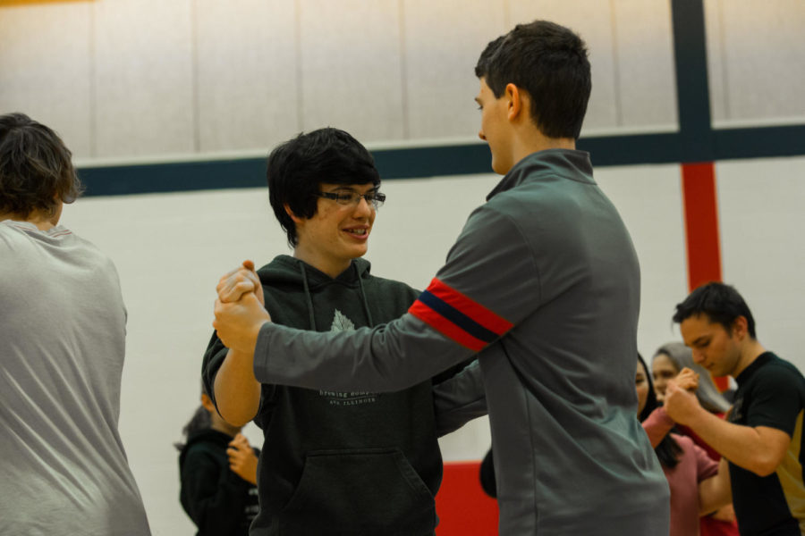 Logan Werning (left) learns to salsa as part of a class experience in the small gym