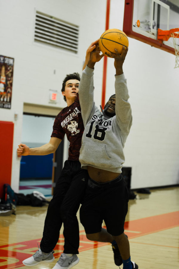 Andrew Fey and Corey Williams play basketball in a P.E. class.