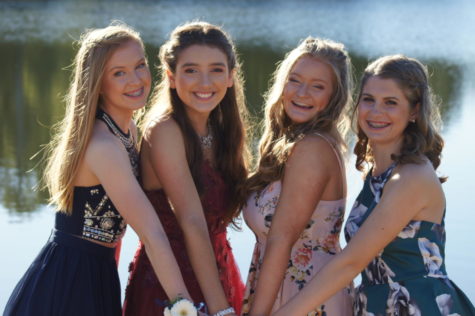 Mya Waldren, Lola Cadice, Grace Pupillo, and Brianna Mills  take pictures in front of a lake before the big dance.