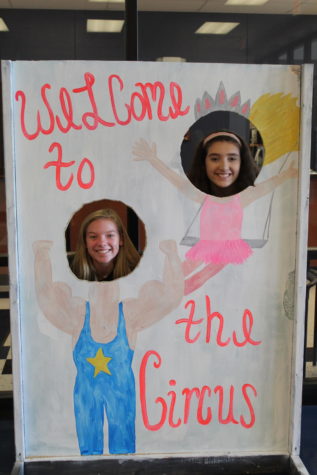 Sophomores Katie Swanson and Lola Cadice pose behind a sign all set up for Libertys 2018 homecoming theme; Welcome to the Circus. 