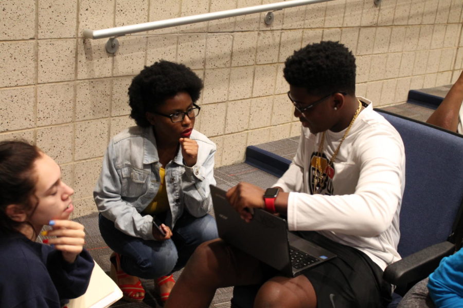 Juniors Grace Wilson, Aminah Lobster and Tai Williams collaborate before the meeting. 