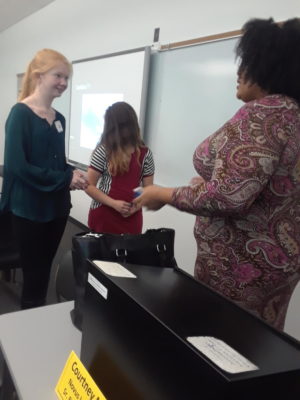 Freshman Maddie Sanderson asks Courtney Loveless Moore a question while she picked up her business card. Approximately 90 students from Computer Science Principles and the Intro to Engineering Design classes traveled to St. Charles Community College for a field trip.