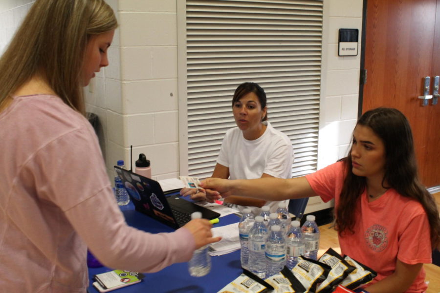 Junior Emily Gann checks in to donate blood with senior Laura Sanders and Mrs. Strathman. 