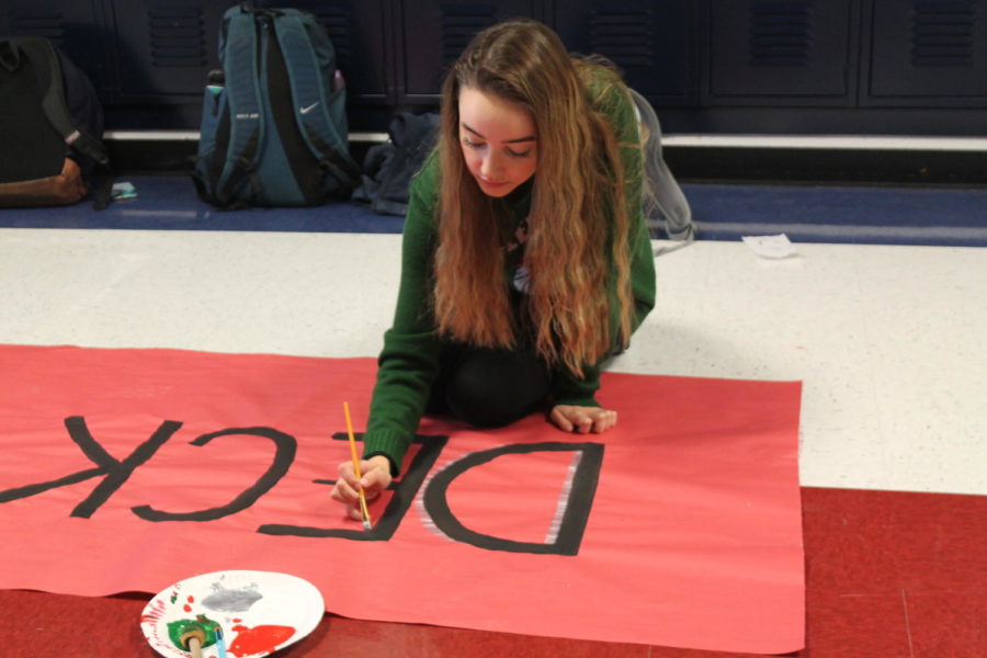 Grace Pickering (10) paints the Deck the Halls sign. 