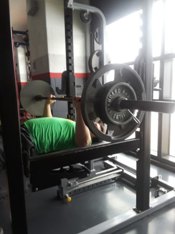 Senior Kevin Roberts works out on the bench press. Weight training is about improving your technique. The coaches teaching this class have had years of experience. They will make sure you know what you are doing.