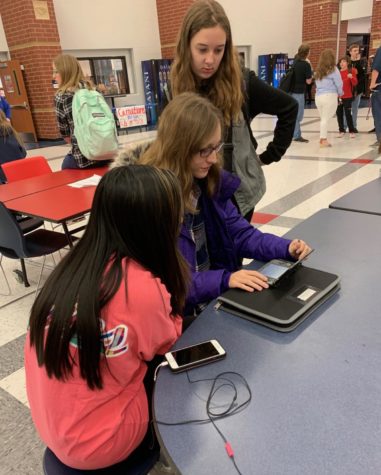 Freshmen Chynna Yeh, (left) Nora Wibbenmeyer, (middle) and Ashley Haberberger (right) play a game in the cafeteria before the first morning bell. 