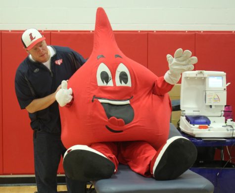 Mr. Wheeler poses with the blood drive mascot. Many students dress up in this costume throughout the day to help promote the blood drive.