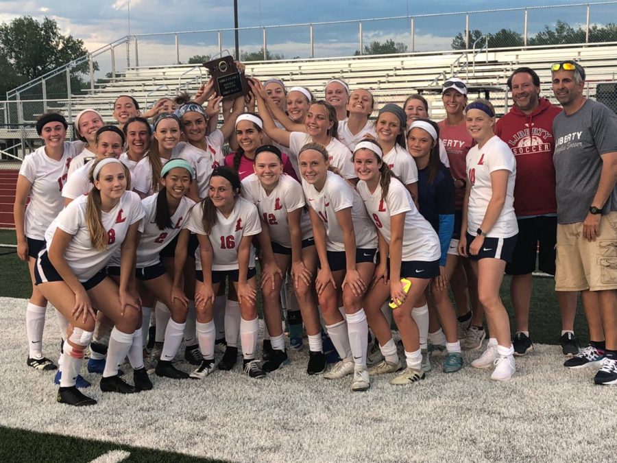 The+varsity+girls+soccer+team+celebrates+their+first+ever+district+championship+when+they+defeated+Helias+5-1+Monday+at+Liberty.+