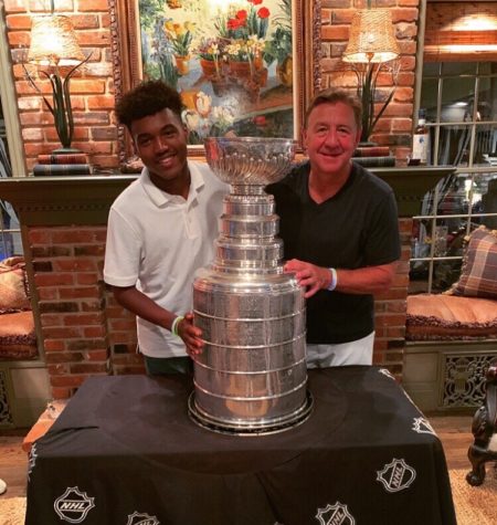 Maliek Merrifield (11) poses with Blues Hall of Famer Bernie Federko and the Stanley Cup. 