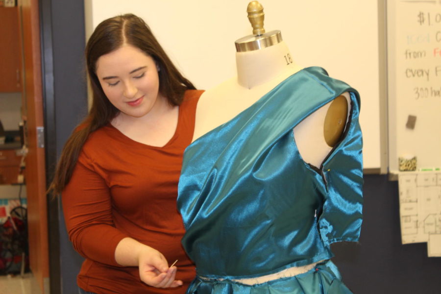 Senior Katelyn Yoder perfects her hand-made dress during class time. 