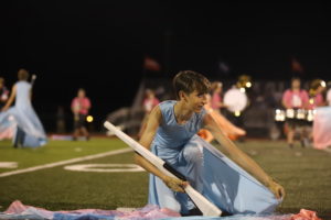 Junior Eric Welker gets ready to spin rifle during halftime at a football game.