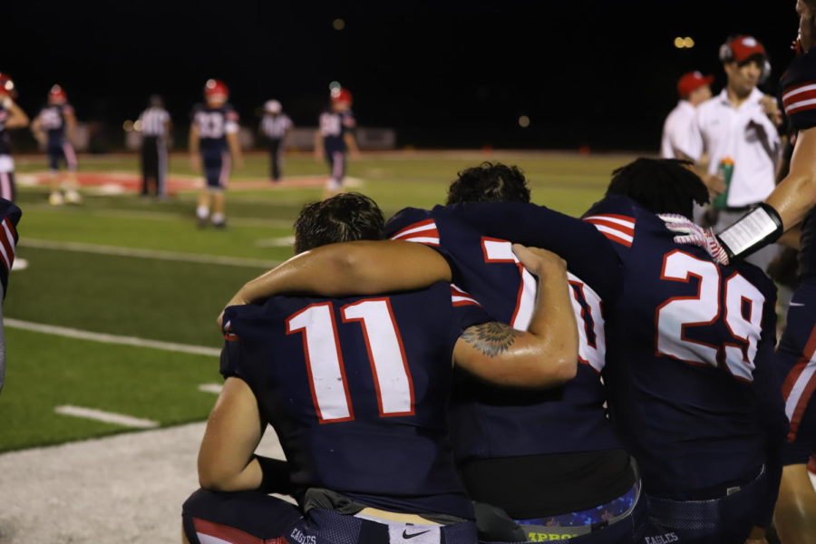 Seniors Cooper Terrell, Gabe Gonzalez and Jeremiah Williams embrace at the end of the senior night football game.