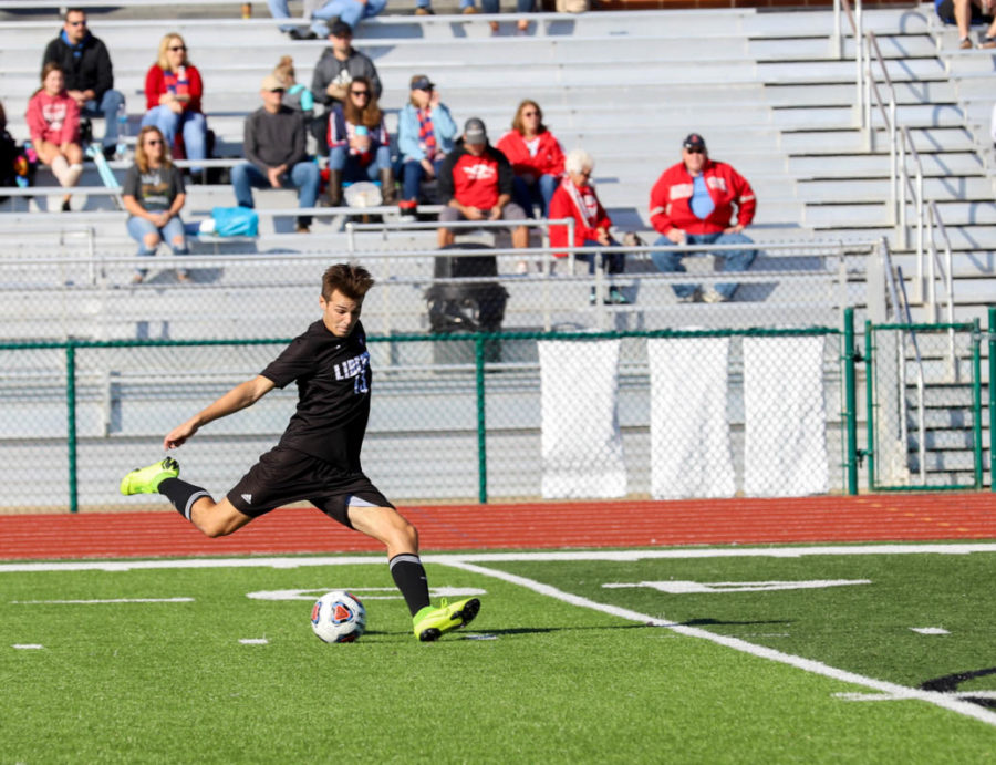 Senior Tyler King crosses the ball to a teammate during a game against Washington on Oct. 19. Liberty won the game 2-0.