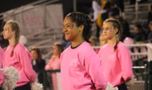 Charity Edney stands with the dance team, watching the Pink Night festivities. 