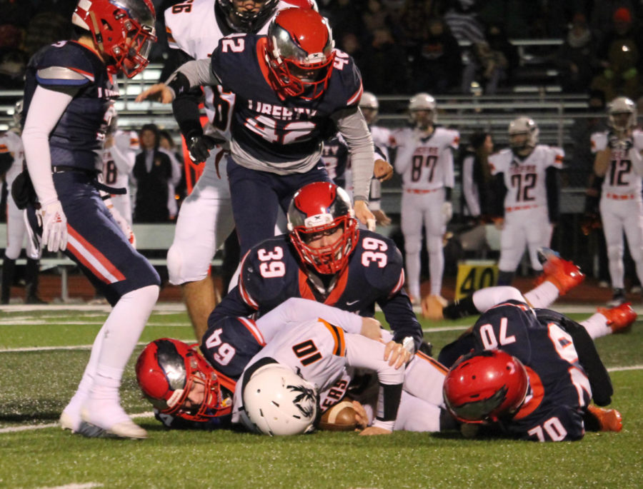 Zach Dotson (39), Anthony Tavolacci (64) and Gabe Gonzalez (70) bring down the Kirksville ball carrier during Libertys victory in the district semifinal game. 