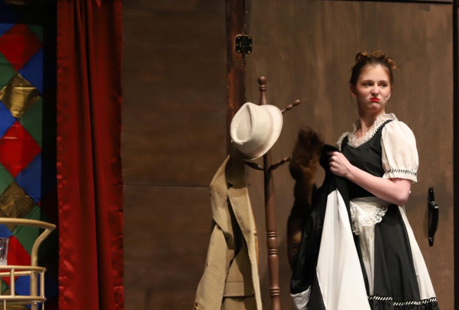 Yvette the maid, portrayed by sophomore Paige Bostic, glares as a guest walks onto stage. 