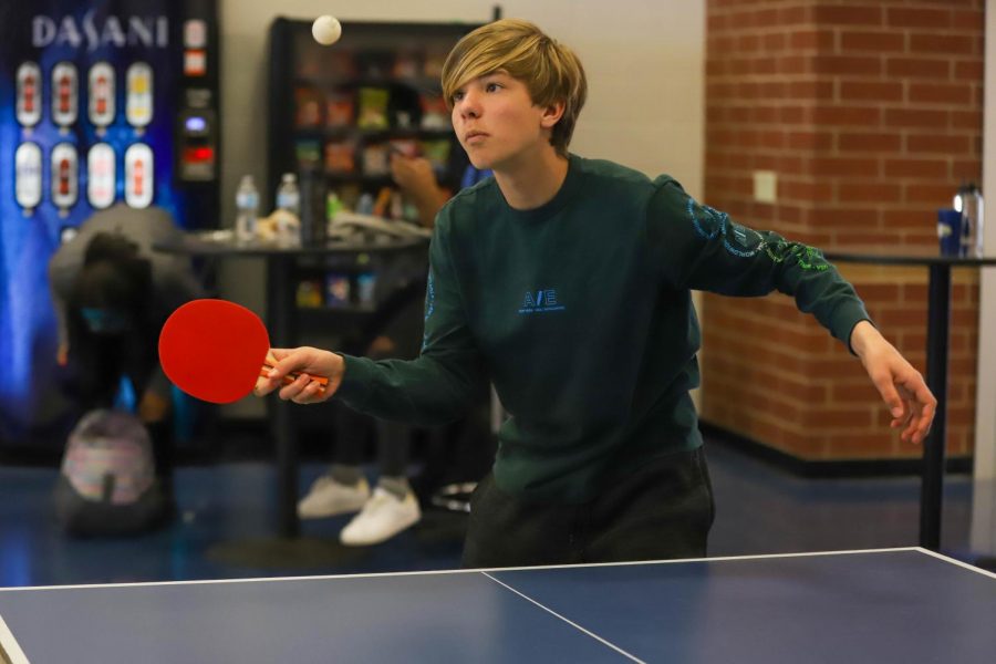 Freshman Schrader Ludwig serves the ping pong ball to his opponent.