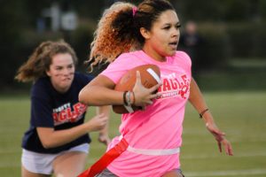 Eve Shelton (12) sprints towards the end zone while Piper Abernathy (11) races to pull her flag. 