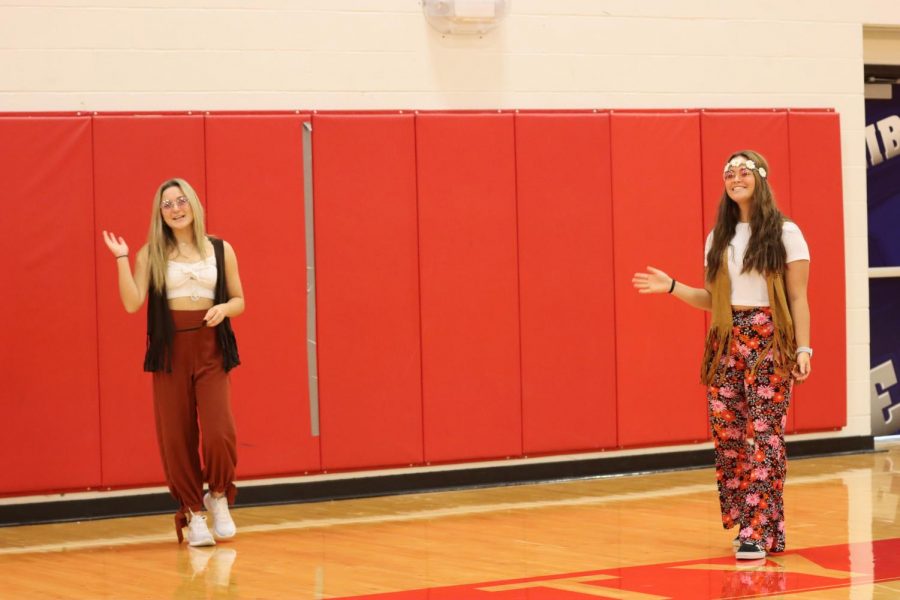 Tess Roberts (left) and Molly Marino (right) kick off the virtual assembly rocking their 70s outfits.