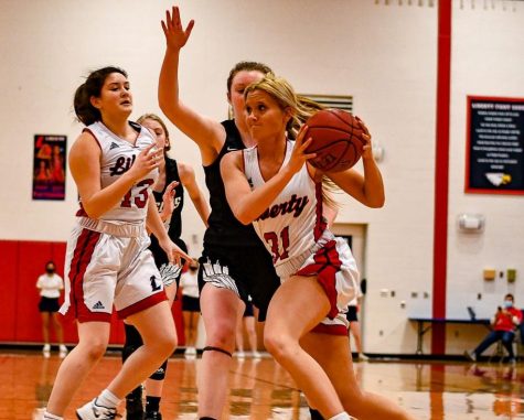 Hailey Jolliff drives past a Orchard Farm defender on her way to the basket, while Ally Schneipp kicks.