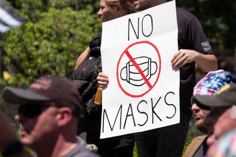 An anti-mask protester holds a sign in front of the Ohio Statehouse on July 18, 2020 in Columbus.