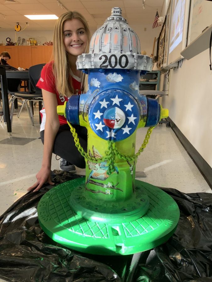 Kelly Karre poses with her fire hydrant that she painted. 