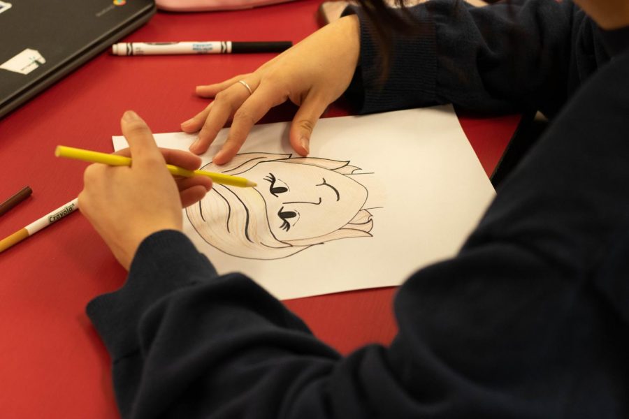 A student draws picture of Princess Diana, a woman who inspires her to hang on the bulletin board. 