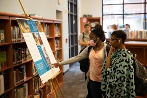 Students soak in the posters stationed around the library, courtesy of the 9/11 Memorial and Museum. 