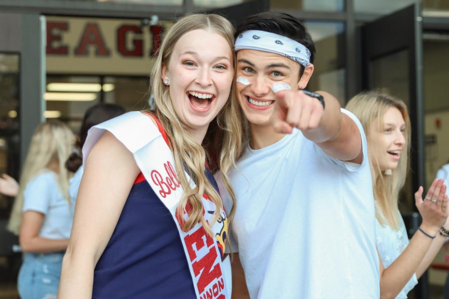 Student Council Vice President and President Bella Bahr (12) & Carson Clay (12) greet students before school for the White-Out game.