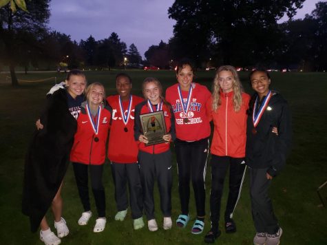 The varsity girls cross country team show their medals after winning conference at McNair Park. The runners were: Fiona Flynn, Jillian Kalbac, Leilani Green, Ally Kruger, Adrienne Rockette, Alexis Omara and Imane Larhdiri.