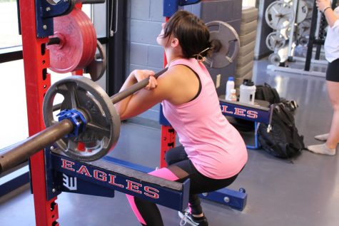 Kaytlee Thompson (12) gets in the eccentric phase of the front squat in weightlifting class. 