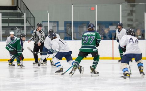 Greyson Howarth (far right) and his teammates battle for a loose puck. 