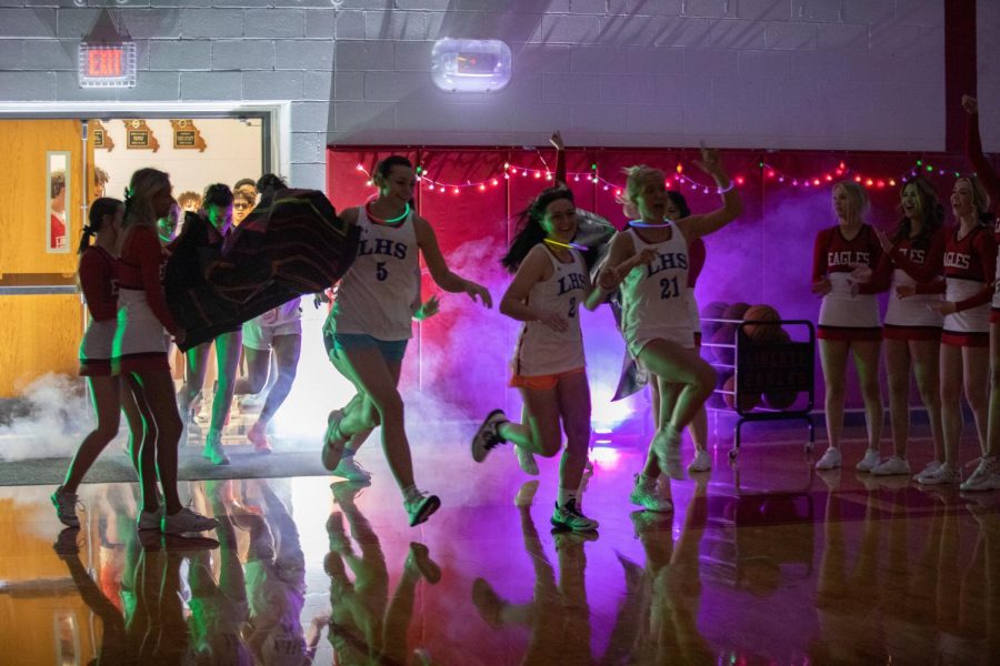 The+varsity+girls+basketball+team+makes+their+big+entrance+at+Midnight+Madness.