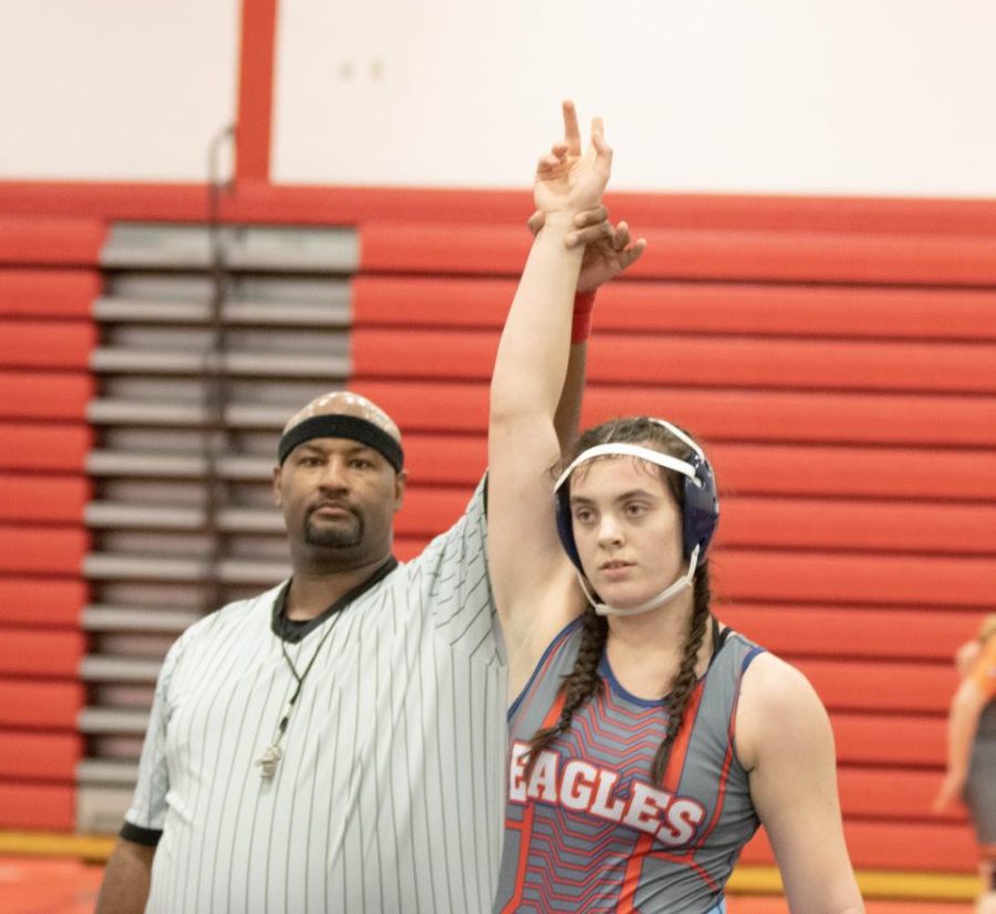 Caroline Ward has her hand raised following a victory over an opponent earlier in the season. Ward was a GAC champion at the conference meet.