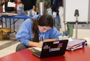 Sydney Strassemeier (10) works on homework after helping set up for Cookies, Cocoa & Cramming.