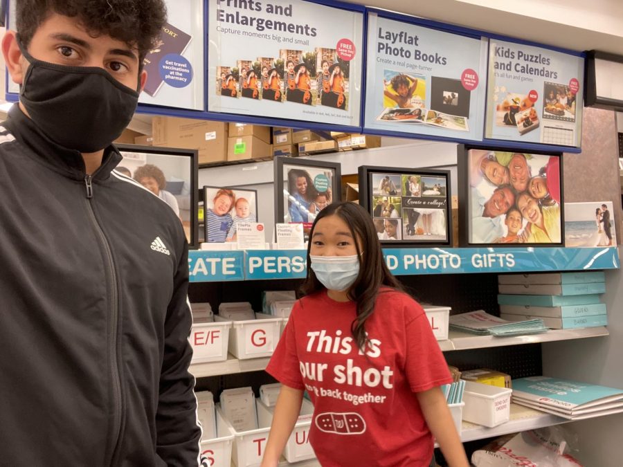 Nader Badwan (12) poses for a picture with a coworker as he puts in more hours as a pharmacy technician. 