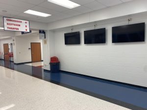 The three new TVs have been installed to replace the previous bulletin board. 