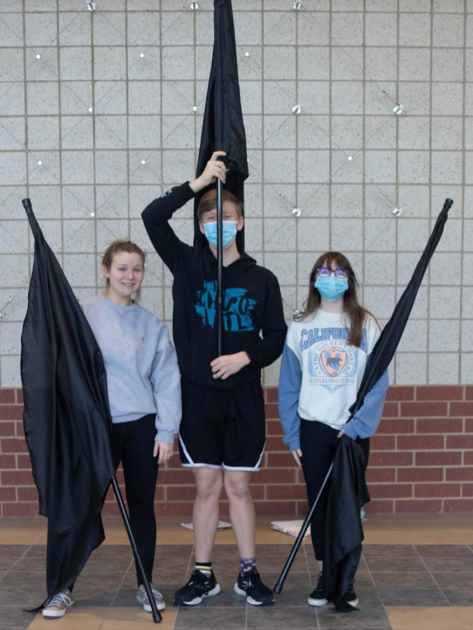 Sydnie Shultis (12), Natalie Hoffman (11), and Benjamin Young (11) pose for a photo with their flags. They took second place at the Mascoutah Competition Jan. 29. The team was eager to be there and I think we did good for our first competition of the season, Hoffman said.