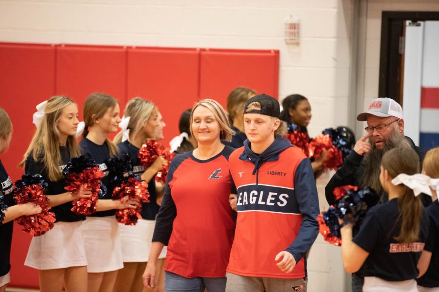 Lukas Aubuchon is escorted by his mom to be celebrated during his senior night.