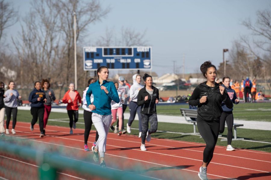 Track players warm up during their second week of practice. 