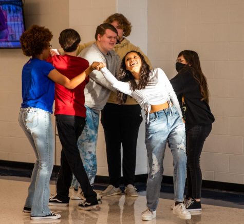 Diana Flores-Cortes (center) attempts to untie a human knot classmates in ELA class. Students were learning about separating positions from motivations, so they all had roles to play in the exercise. Everyone had the goal of untying the knot, but some people had to be in charge, make everyone happy, be distracted, etc. This is part of an essay unit where they will have to mediate an issue and find a compromise, Mr. Eversole said. 