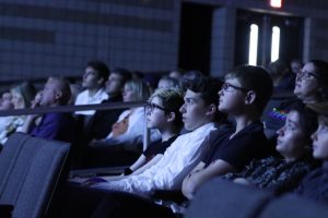 The audience focuses on a screen presenting student films at North Point High School.  