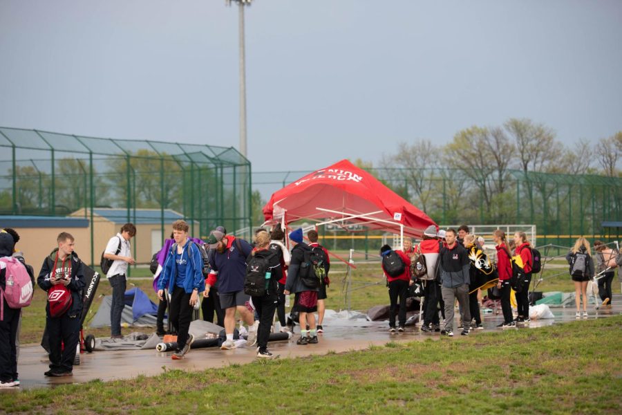 Athletes move their schools tent after it blew away during the storm. 