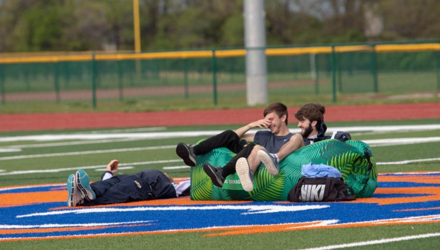 Sam Coppedge and Dominic Lancaster sit on an inflatable couch watching the track meet after the storm. 