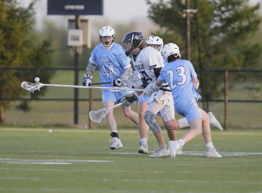 Defenseman Colby Adelsberger keeps possession of the ball in a game versus Francis Howell on April 26.