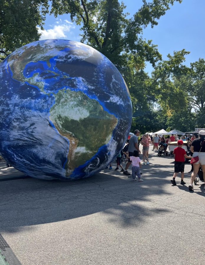 Many people gathered around the Earth globe in the main plaza of Tower Grove during the Festival of Nations.